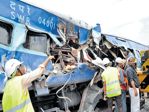 Railway workmen try to clear the mangled remains of the Bangalore City-Nanded Express H-1 AC coach that was rammed by a truck on Monday, killing five, including (inset) MLA A Venkatesh Naik and T S D Raj from Bengaluru. DH Photo/Srikantha Sharma R