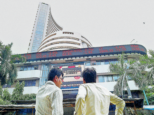 Investors react while watching stock prices at the BSE in Mumbai on Monday. PTI