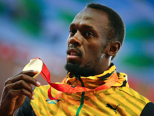 Usain Bolt of Jamaica presents his gold medal after winning the men's 100m event during the 15th IAAF World Championships at the National Stadium in Beijing. Reuters