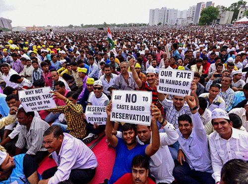 Patidar community members display placards during their Kranti Rally for reservation at GMDC Ground in Ahmedabad on Tuesday. PTI Photo