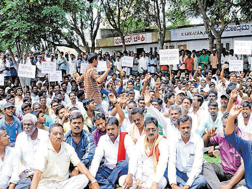 Construction workers stage a protest seeking fulfillment of their various demands in Chamarajanagar on Tuesday. DH photo