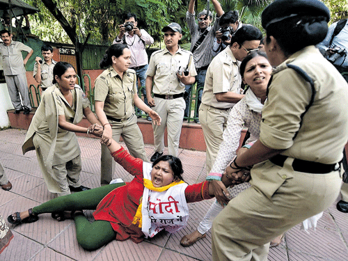 Police hold an activist during the protest by Youth Congress workers against hike in the prices of vegetables, in New Delhi on Tuesday. PTI