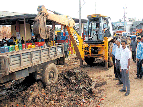 APMC President S T Chandregowda inspects the cleanliness work at APMC yard in Chikkamagaluru on Wednesday. DH photo