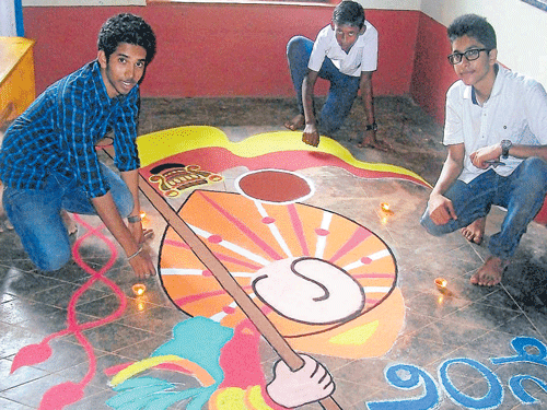 Students of St Aloysius High School Atul S&#8200;K and Dhare Gowda with help from young artist Jeevan Acharya and under the guidance of art teacher John Chandran, drew the logo of Kannada literary meet in rangoli, measuring 10 ft X 15 ft, on the eve of the meet at Kateel on Thursday. DH photo