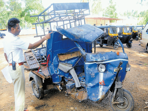 A traffic constable inspects the mangled goods autorickshaw which was hit by a lorry killing&#8200;Nagu, 18, at Yaraganahalli Circle in Mysuru on Friday. DH photo