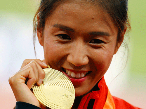 Liu Hong of China presents her gold medal as she poses on the podium after the women's 20 km race walk event during the 15th IAAF World Championships at the National Stadium in Beijing, China, August 28, 2015. REUTERS