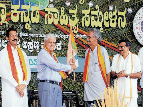 District Kannada literary meet former president K P Rao (2nd right) hands over the flag to the current president Dr N Sukumar Gowda, as MP Nalin Kumar Kateel  and others look on. DH photo