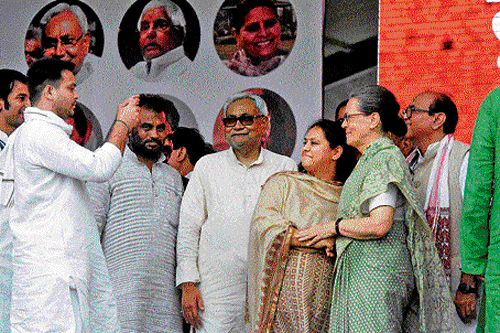 picture perfect:Congress president Sonia Gandhi and Bihar Chief Minister Nitish Kumar pose for a photograph with RJD chief Lalu Prasad's daughter and RJD leader Misa Bharti as Tejaswi Yadav, son of Lalu, clicks photos during the Swabhimaan rally at Gandhi Maidan, in Patna on Sunday.  pti