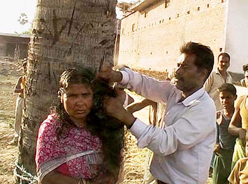 A villager cutting the hair of a woman, Lalpari Devi alias Anita Devi, believed to be a witch, at Dumariya-Adlakchak village in Maner. PTI file photo