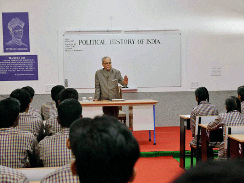 President Pranab Mukherjee teaching students at a Government School on the occasion of Teachers Day in New Delhi on Friday. PTI Photo
