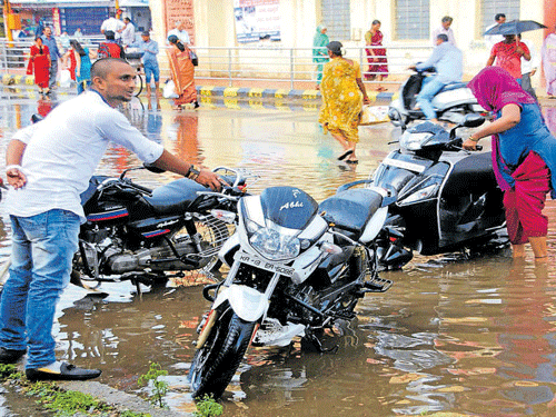 inundated: The road near NR Circle was waterlogged due to a sudden downpour, in Hassan, on Friday. DH&#8200;Photo