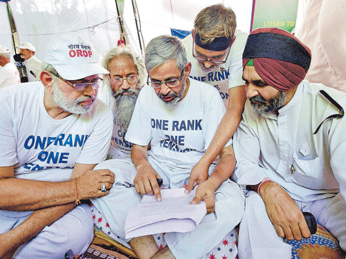 Ex-servicemenwho are on hunger strike, read government's proposal of the implementation of One Rank One Pension (OROP) schemeat JantarMantar inNewDelhi on Saturday. PTI