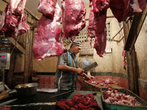 A butcher cuts meat for a customer inside his shop in Mumbai.  India's financial capital has banned the slaughter and sale of meat for four days this month following a demand from the strictly vegetarian Jain community, sparking outrage among meat-eaters already upset by a permanent beef ban imposed this year. Reuters photo