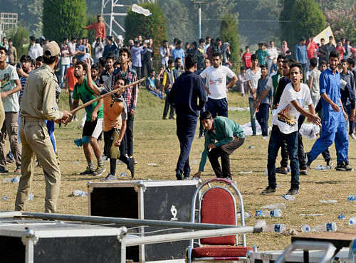 Youth throws stones and water bottles after clashes erupted during the first International Kashmir half Marathon, at Kashmir University campus, in Srinagar on Sunday. PTI Photo