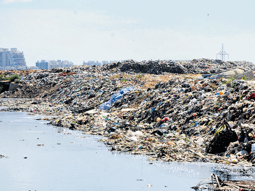 ANOTHER MANDUR? Around 500 metric tonnes of garbage from the City is being dumped at Bingipura landfill site near Anekal. (Right) Methane bubbles out at the landfill site. (Below) Passersby find the stench unbearable as garbage lies uncleared at Kalasipalya, following the protests at Bingipura. DH&#8200;PHOTOs/S K Dinesh