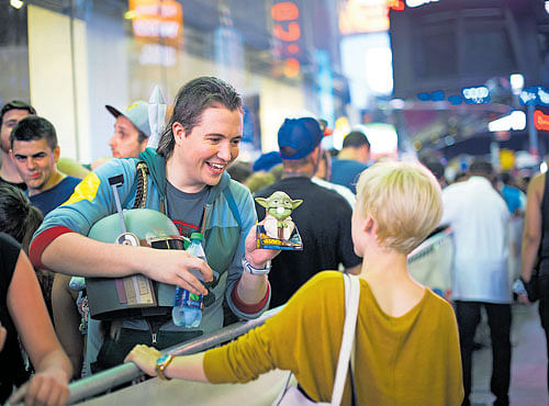 STAR STRUCK: Alexander Stine plays with a toy Yoda hewon by correctly answering a StarWars trivia question, while lined up outside the Toys R Us store in Times Square hours before toys tied to the new Star Wars film were released, in NewYork. NYT