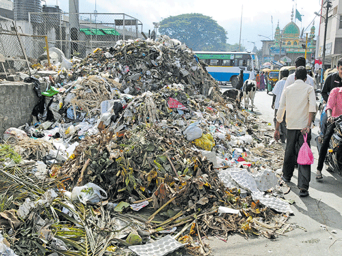 easy times ahead: Now that trash trucks are being allowed into the landfill site at Bingipura, uncleared garbage, like this on SJP Road, is expected to be cleared soon. dh Photo