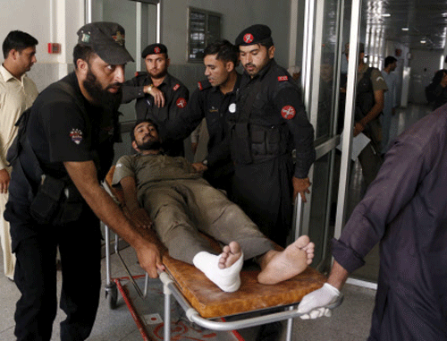 Emergency workers wheel an injured man to a hospital after an attack on an air force base in Peshawar. Reuters photo