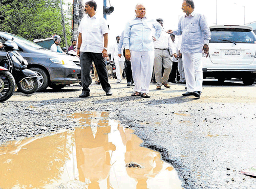 Bengaluru Urban district Minister Ramalinga Reddy spots a crater-sized pothole at Iblur near Bellandur during his inspection on the Outer Ring Road on Thursday. DH PHOTO