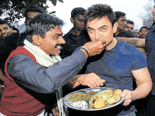 Brij Bihari Rai offering litti-choka to superstar Aamir Khan during the actor's visit to his shop in Patna. Mohan Prasad