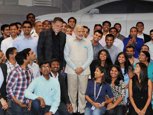 Prime Minister Narendra Modi and Elon Reeve Musk, CEO and Product Architect of Tesla Motors with employees pose a photo during a visit of TESLA motors facility in San Jose on Saturday. PTI Photo