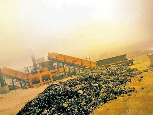 up in flames: An earthmover that was set on fire at the waste processing unit (right) which was ransacked by villagers at Kannahalli on Magadi Road on Saturday night.  dh photoS/s K DINESH