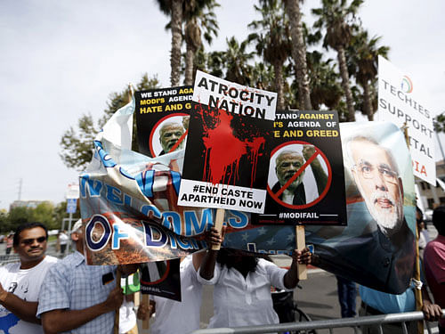 Demonstrators hold signs in protest against Indian Prime Minister Narendra Modi before a community receptiion outside SAP Center in San Jose, California September 27, 2015. REUTERS