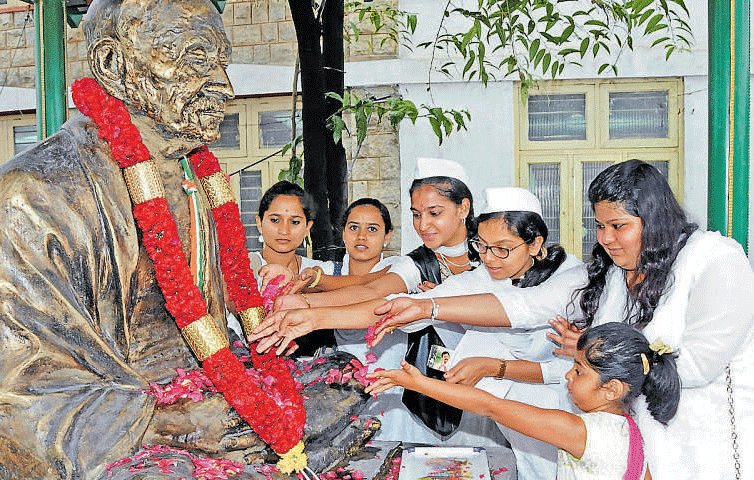 Students offer floral tributes to Mahatma Gandhi at Gandhi Bhavan in the City on Friday. DH PHOTO