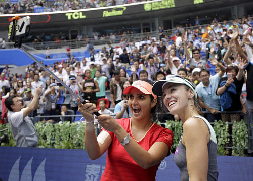 Hingis of Switzerland and Mirza of India pose for pictures as they celebrate after winning their women's doubles final match at the Wuhan Open tennis tournament. Reuters photo