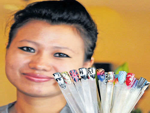 bright hues An artist with a variety of nail art designs.