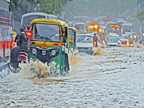 MArooned Vehicles make their way through the waterlogged Old Madras Road in Bengaluru on Sunday. DH&#8200;PHOTO