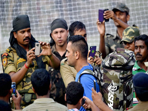 Secitiry persons clicking photos of MS Dhoni in their cellphones during the training session prior to the 2nd T20 Match against India at Barabati Stadium in Cuttack on Sunday. PTI Photo.