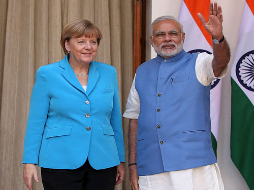 India's Prime Minister Narendra Modi gestures as German Chancellor Angela Merkel (L) watches during a photo opportunity ahead of their meeting at Hyderabad House in New Delhi, India, October 5, 2015. REUTERS Photo