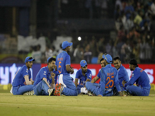 India players sit on the field after the match was disrupted due to water bottles thrown by spectators during the second Twenty20 cricket match against South Africa in Cuttack. Reuters Photo