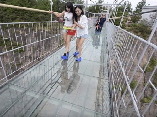 Hundreds of tourists flocked to the recently built glass bridge at the Yuntai Mountain walkway in China's Henan province which developed cracks under the weight of huge crowd on Monday. Screen grab.