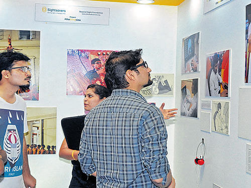 Visitors take a look of photographs of and taken by visually impaired people at Garuda Mall on Saturday. DH PHOTO