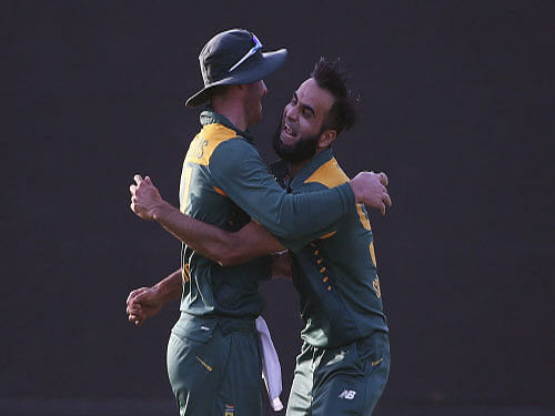 South Africa's Imran Tahir celebrates with AB de Villiers after dismissing India's Suresh Raina during their first one-day international cricket match in Kanpur. Reuters photo