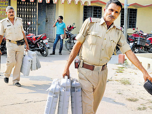Police personnel carryEVMmachines to polling booths ahead of the first phase of Bihar assembly polls, in Smastipur, on Sunday. PTI