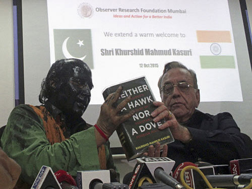Sudheendra Kulkarni, chairman of the Observer Research Foundation Mumbai, with his face smeared with black ink, holds a copy of a book by former Pakistani foreign minister Khurshid Mahmud Kasuri (R) during a news conference in Mumbai. Reuters photo