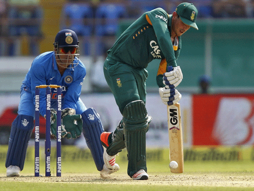 South Africa's de Kock plays a shot watched by India's captain and wicketkeeper Dhoni during their third one-day international cricket match in Rajkot. Reuters photo.