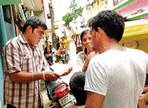 Volunteers talk to potential RTE parents during a weekend awareness drive. DH PHOTO