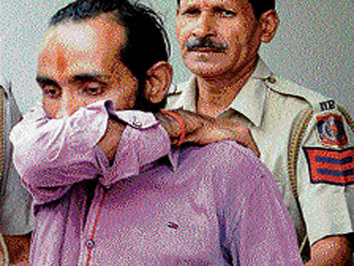 Uber cab driver Shiv Kumar Yadav being taken by police in New Delhi on Tuesday. PTI