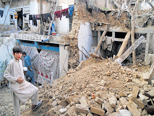 REMAINS&#8200;OF&#8200;THE&#8200;DAY: A boy stands on the rubble of houses after an earthquake in Kohat, Pakistan on Monday. AFP