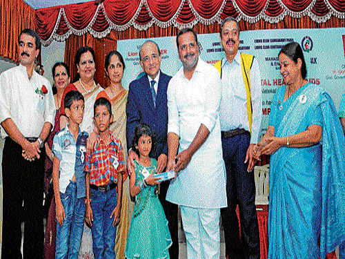 Health and Family Welfare Minister U T Khader distributes hearing aids to children at a programme in Mangaluru on Wednesday. Lions District Governor Kavita Shastry, senior ENT surgeons Dr Hans and Dr Vasanti look on. DH Photo