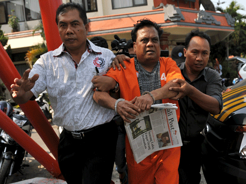 Indonesian plainclothes policemen escort Indian gangster Rajendra Nikalje, widely known as Chhota Rajan, as they walk at Denpasar police office October 29, 2015. Reuters Photo.