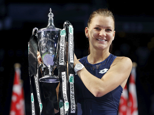 Agnieszka Radwanska of Poland celebrates with her trophy after defeating Petra Kvitova of the Czech Republic in their women's singles finals tennis match of the WTA Finals at the Singapore Indoor Stadium. Reuters Photo.