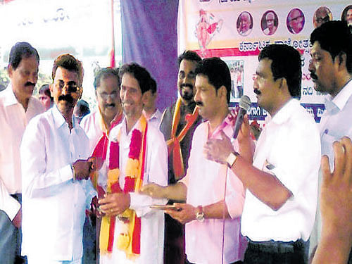Kannada Katte and Karavali Karnataka Rakshana Vedike members honour Ullal Uday Gatti with 'Nada Nayaka' award during the Kannada Rajyotsava celebrations in Mangaluru on Sunday. Dh photo