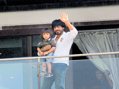 Shah Rukh Khan holds his son AbRam as he waves to fans and well-wishers gathered outside his residence  on his 50th birthday in Mumbai on Monday. PTI