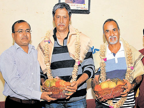 Chief Conservator of Forest Manoj Kumar felicitates wildlife photographers Krupakar and Senani at an interaction organised by Mysore District Journalists' Association in Mysuru on Wednesday. DH photo
