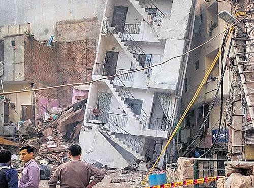 Five-year-old four-storey building tilted on Sunday morning over the adjoining one creating panic. DH PHOTO
